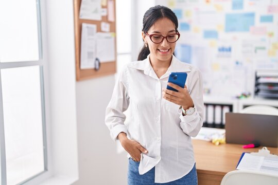 Young beautiful hispanic woman business worker smiling confident using smartphone at office