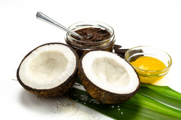 Coconut halves, chocolate paste and honey on white background. Homemade carob butter with ingredients. Healthy sweet food concept