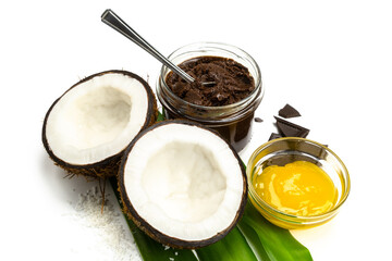 Coconut halves, chocolate paste and honey on white background. Homemade carob butter with ingredients. Healthy sweet food concept - obrazy, fototapety, plakaty