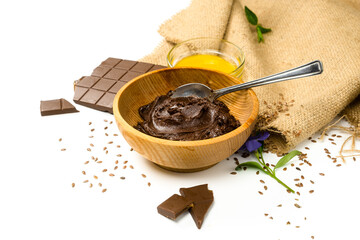 Chocolate paste in wooden bowl and ingredients. Chocolate butter and honey on white background....