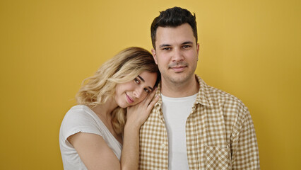 Man and woman couple smiling confident standing together over isolated yellow background