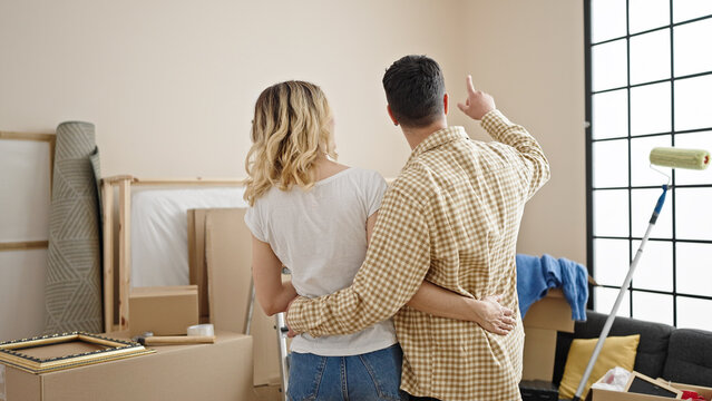 Man and woman couple hugging each other on back view at new home