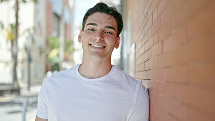 Fototapeta premium Young hispanic man smiling confident standing at street