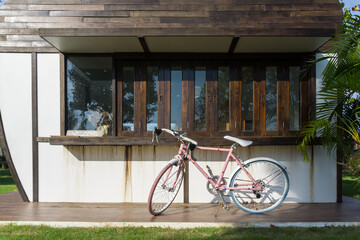 A pink bicycle is parked at the entrance of a cafe with a welcome sign