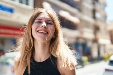 Young blonde woman smiling confident standing at street