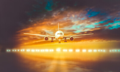 plane lands on the runway on a background of a magnificent sunset