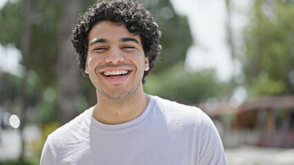 Young latin man smiling confident standing at park