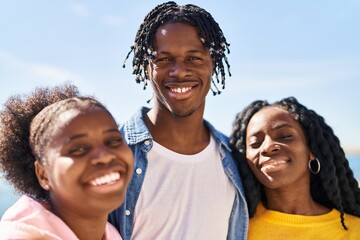 African american friends smiling confident standing together at seaside