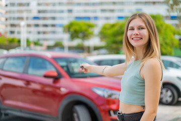 Young blonde woman at outdoors holding car keys