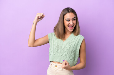 Obraz premium Young caucasian woman isolated on purple background celebrating a victory