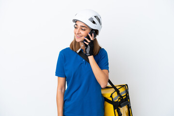 Young caucasian woman with thermal backpack isolated on white background keeping a conversation with the mobile phone
