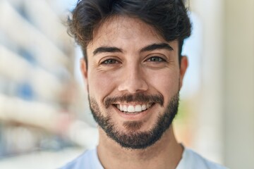 Fototapeta premium Young hispanic man smiling confident standing at street