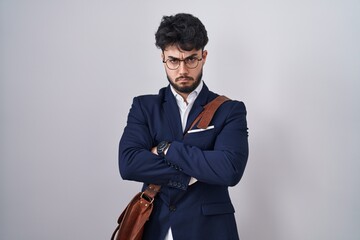Hispanic man with beard wearing business clothes skeptic and nervous, disapproving expression on face with crossed arms. negative person.