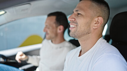 Two men couple smiling confident driving car at street