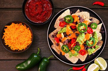 Fully loaded nachos with beef and cheese. Mexican food dish. Top down view table scene on a dark...
