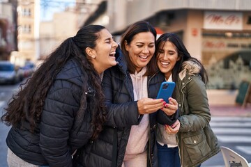 Three woman mother and daughters using smartphone at street