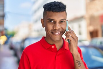 Young latin man smiling confident talking on the smartphone at street