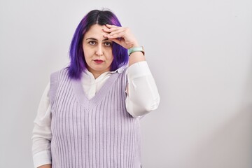 Plus size woman wit purple hair standing over white background worried and stressed about a problem with hand on forehead, nervous and anxious for crisis