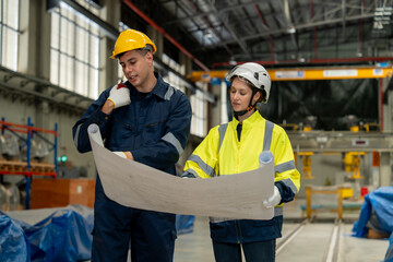 Technical staff together with engineers inspect the structure of the electric train's propulsion system in order to maintain the electric train in the depot.