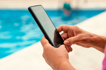 anonymous senior woman uses mobile phone in swimming pool