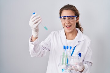 Young caucasian scientist woman working with laboratory samples smiling and laughing hard out loud because funny crazy joke.