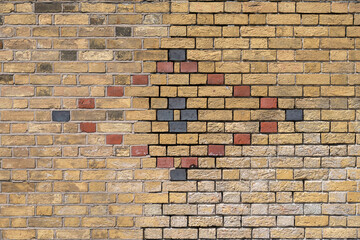 Brick wall with diamond pattern in red and blue bricks, repaired, with missing pointing