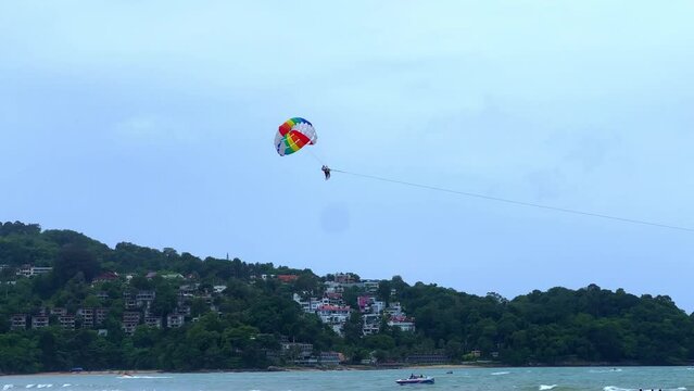 Parasailing on a windy day at Patong Beach phuket thailand. Speed boats and jet sky&rsquo;s roaming 