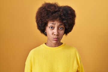 Young african american woman standing over yellow background depressed and worry for distress, crying angry and afraid. sad expression.