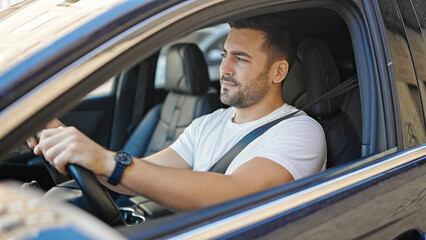 Young hispanic man smiling confident driving car at street