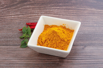 Yellow vibrant curcuma powder in the bowl
