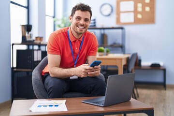 Fototapeta premium Young hispanic man business worker using laptop and smartphone working at office
