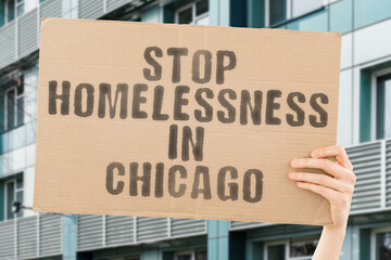 man's hand firmly grasps a banner that reads ' Stop Homelessness in Chicago '. The plight of...