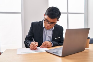 Down syndrome man business worker writing on document at office