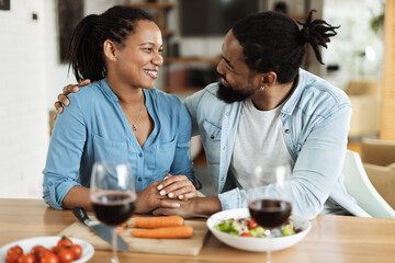 Fototapeta na wymiar Happy African American couple talking while enjoying in lunch time at dining table.