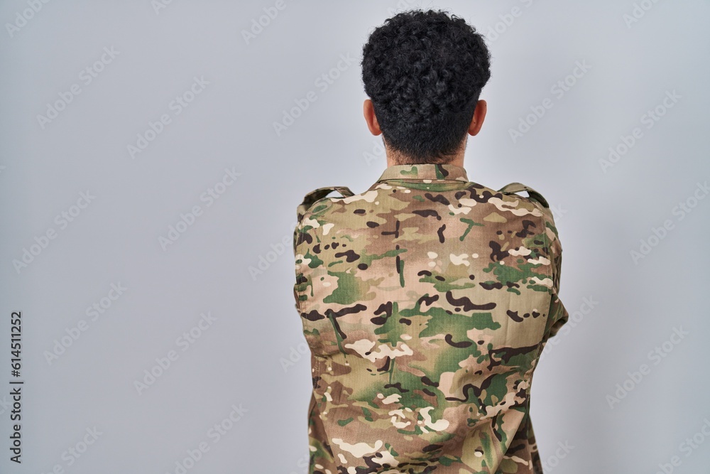 Sticker arab man wearing camouflage army uniform standing backwards looking away with crossed arms