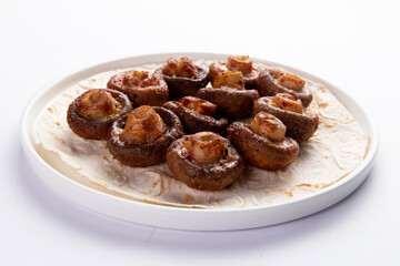 Grilled champignon mushrooms. On a white background.