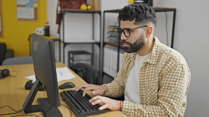 Young hispanic man business worker using computer working at office