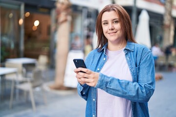 Young beautiful plus size woman smiling confident using smartphone at coffee shop terrace