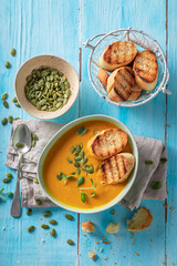 Vegan pumpkin soup served with toasted bread.