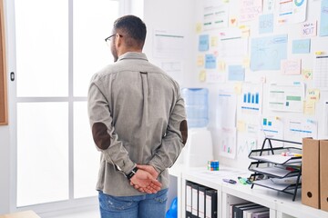 Young hispanic man business worker looking throw the window at office