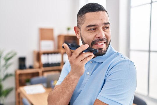 Young latin man business worker smiling confident talking on smartphone at office