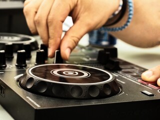 hands of a young Man playing a dj controller