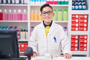 Young hispanic kid working at pharmacy drugstore with a happy and cool smile on face. lucky person.
