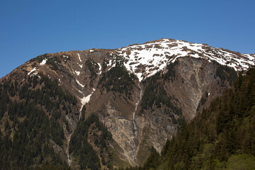 scenic landscape photograph of the snowcapped mountains of Alaska from the ocean view.