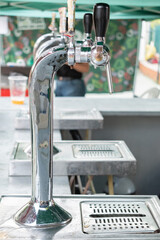 Taps of beer lined up at a street stall. Summer street festivals.