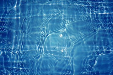 Blue water with ripples on the surface. Defocus blurred transparent blue colored clear calm water surface texture with splashes and bubbles. Water waves with shining pattern texture background.