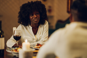 Smiling african american woman celebrating anniversary or Valentines day with her partner at home