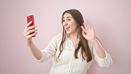 Young beautiful hispanic woman smiling confident having video call over isolated pink background