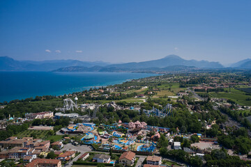 Fototapeta na wymiar Amusement park, attractions on Lake Garda in Italy, aerial view. Aerial panorama of the popular amusement park on Lake Garda. Sights of Italy.