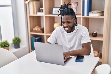 African american woman using laptop sitting on table at home